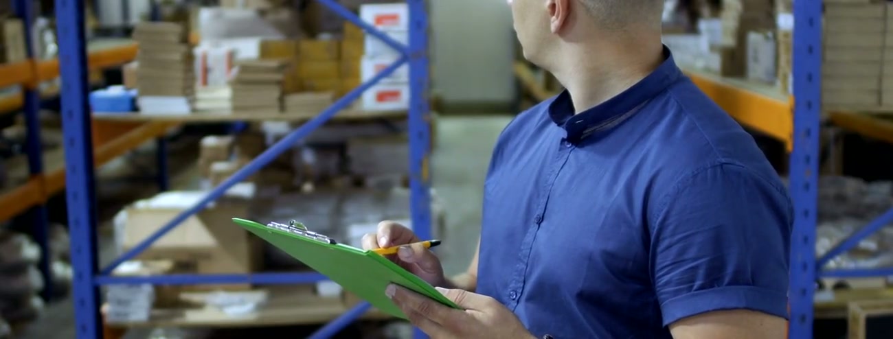 Factory supervisor walking through packed goods ready for dispatch